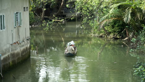 Hombre-Irreconocible-Remando-En-Una-Canoa-A-Través-De-Un-Río,-Vietnam