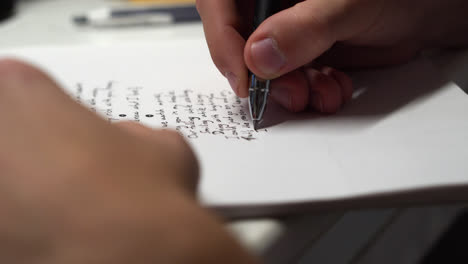 mano de una persona creativa escribiendo un poema sobre la mesa