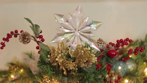 arranging top of christmas tree with decorations and opalescent star