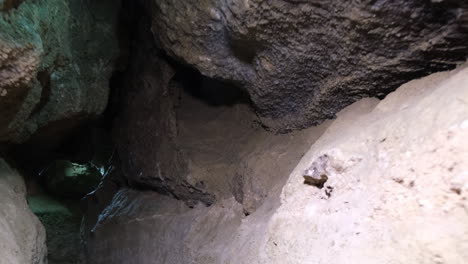 exploration of a breathtaking cave with sunlight filtering through the entrance sunlight streams through the entrance of a vast cave illuminating the stone walls and creating a mystical atmosphere the rocky terrain leads to a serene shadowy pool of water