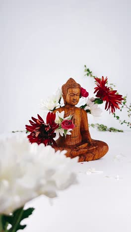 wooden buddha statue with flowers