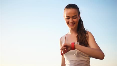 mujer comprobando el reloj inteligente al aire libre