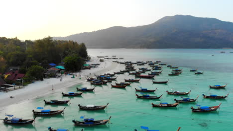 Fly-over-boats-anchored-on-a-paradisiac-beach-at-sunrise-in-Thailand