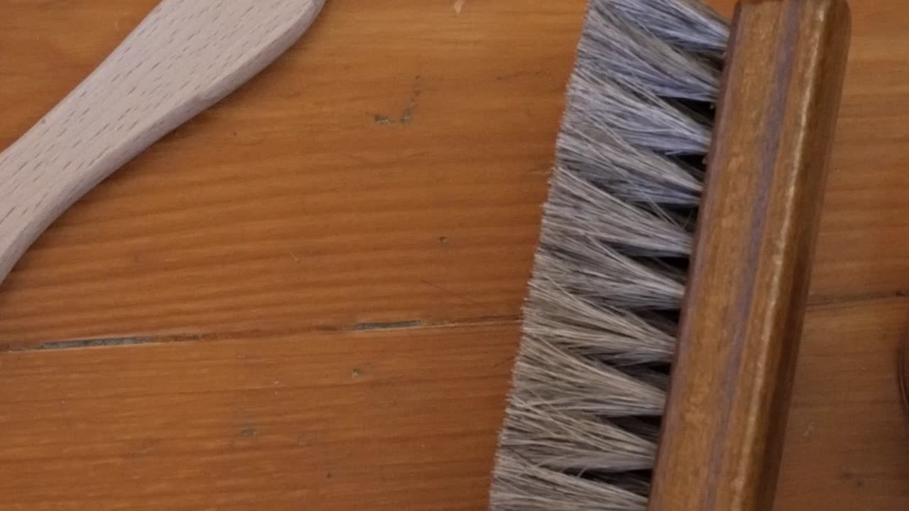 Shoe polishing tools on a wooden table evoke artisanal craftsmanship
