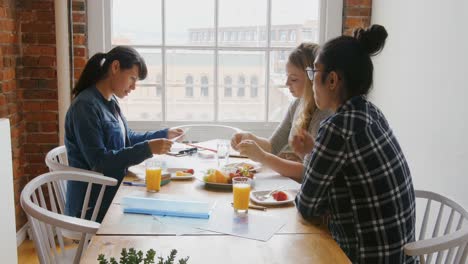 businesswomen discussing over documents while having breakfast 4k