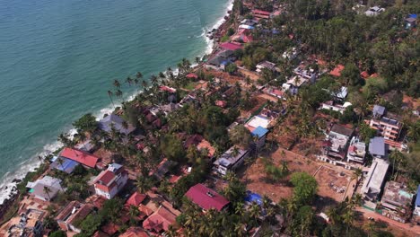 aerial drone shot of varkala beach filled with shops, buildings and trees