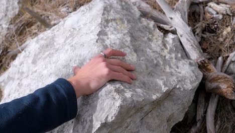 slow motion close-up shot of a man using both hands to climb up a steep hiking route