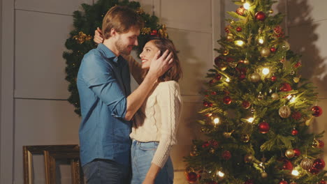 couple hugging by christmas tree