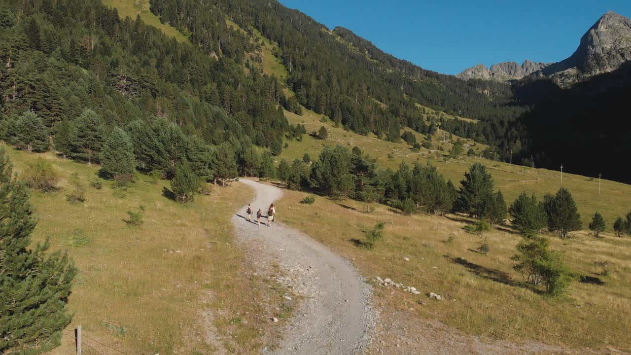 Aerial drone shot of friends walking through a mountain path