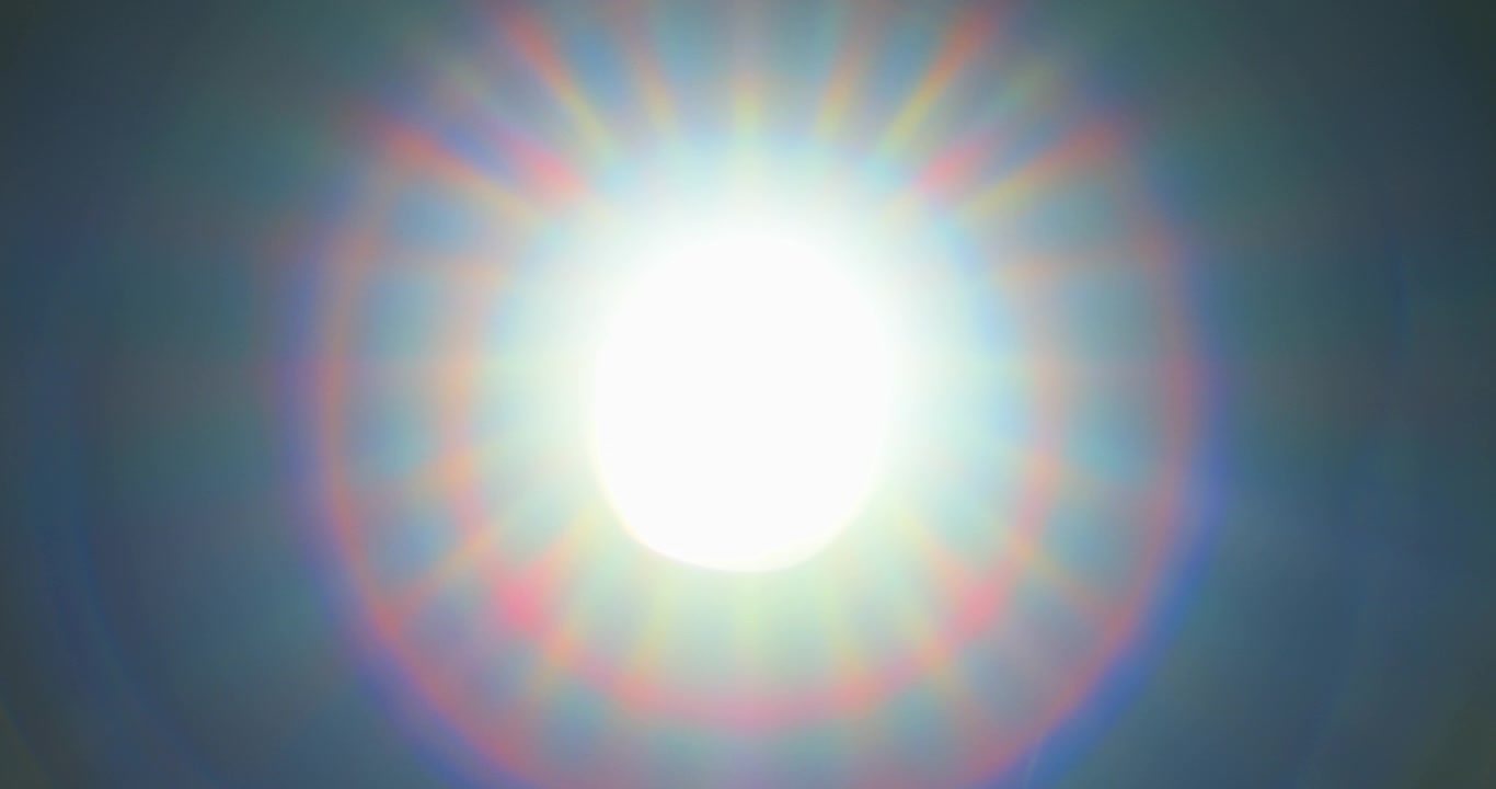 Diaphragm blades opening fast with sun rays shining through old camera lens, fade out to white