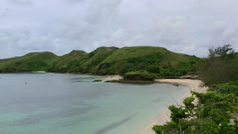white sand coastline on cloudy day at bukit merese in south lombok, aerial