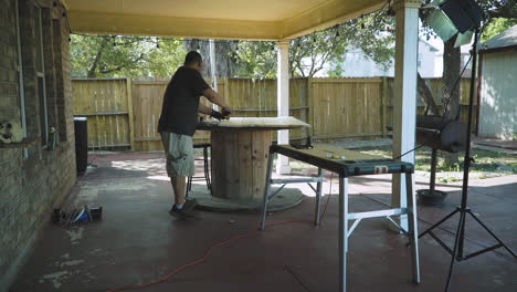 carpenter assembling and measuring wood table