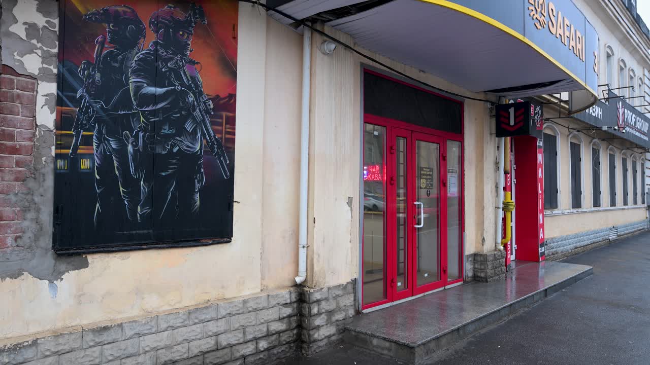 A shop selling military gear in wartime Kharkiv, Ukraine. A large image of soldiers on the building's facade highlights how the conflict has become part of the city's daily life