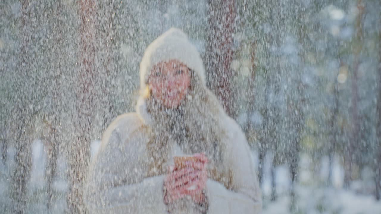 Woman enjoying a hot drink in a snowy forest