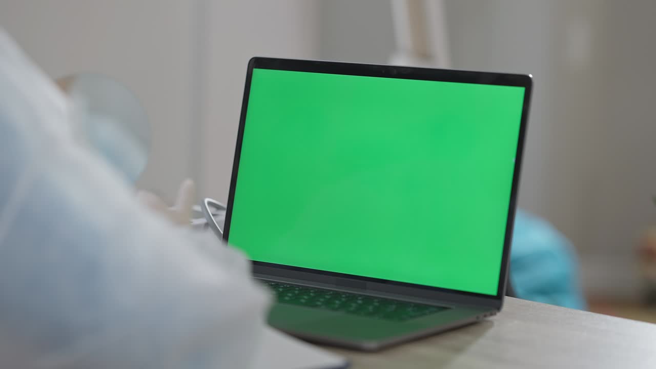 primer plano de la computadora portátil chromakey con un médico irreconocible sentado en la mesa hablando. mujer caucásica profesional consultando en línea sobre el brote de la pandemia de coronavirus usando chat de video en pantalla verde.