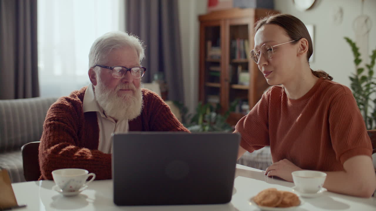 Elderly Man Learning How to Use Internet on Laptop with Help of Daughter