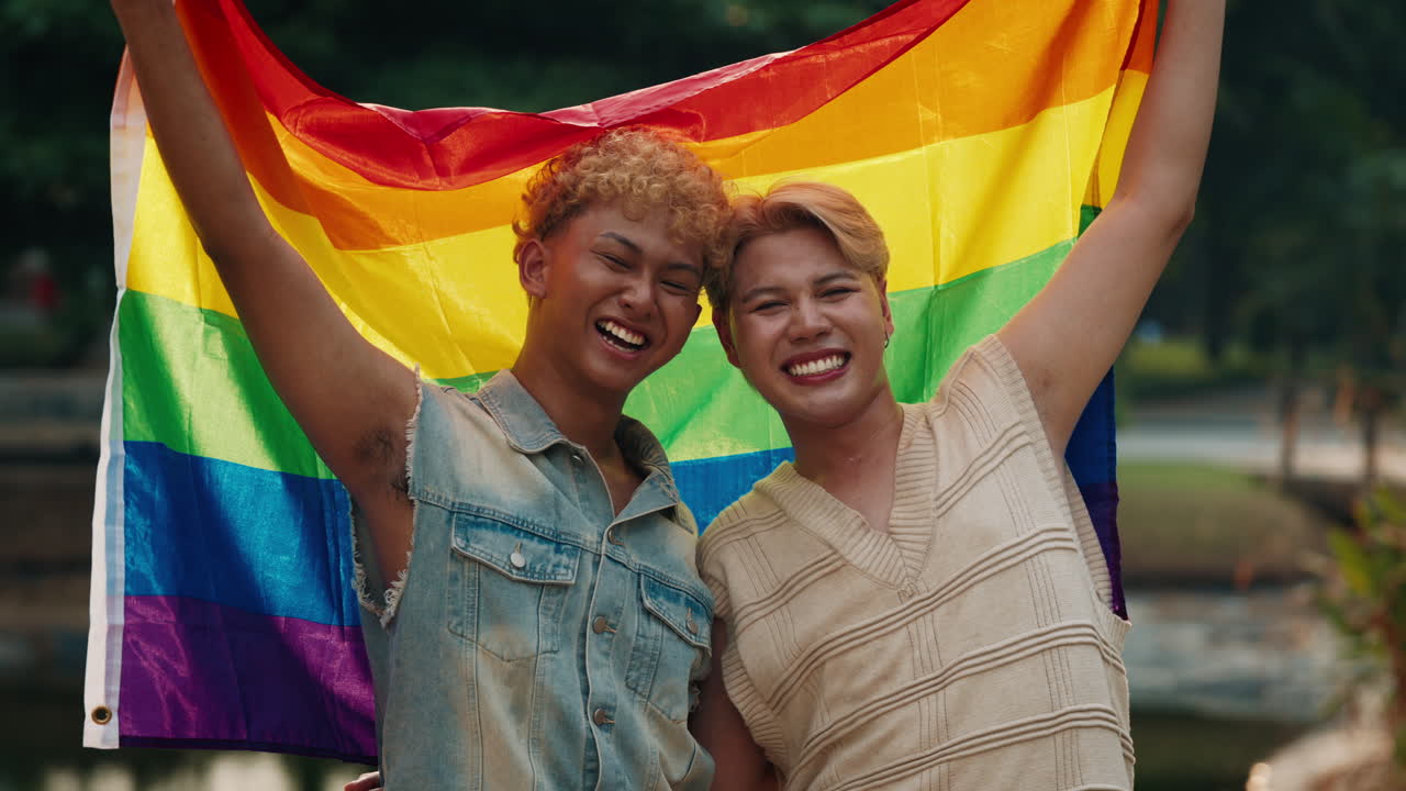 Two happy people with LGBTQ rainbow flag