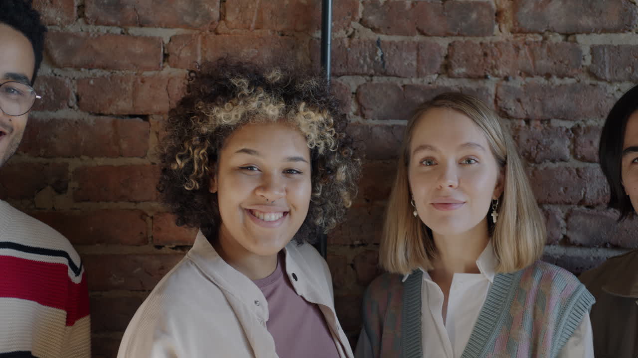 Three Friends Posing in Front of a Brick Wall