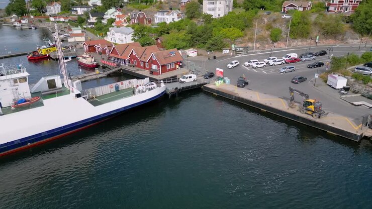 Auto che si imbarcano sul traghetto in un bel porto di paese in Svezia