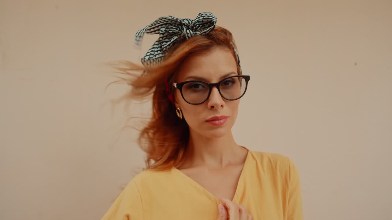 Portrait of a fashionable woman with red hair, glasses, and a headband