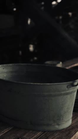 a close-up of a rustic green metal bucket on a wooden table