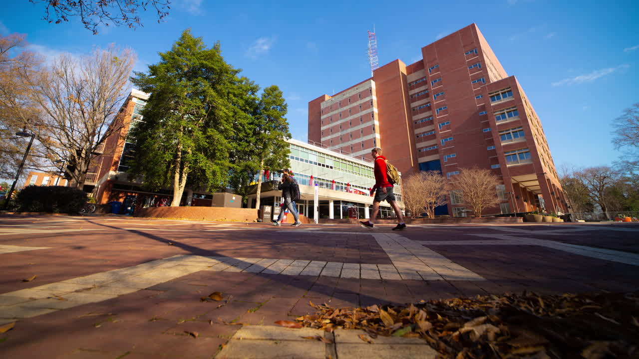 People Walking By The Main Library Building Of North Carolina State University In Raleigh, NC On A Sunny Day. low-level, timelapse