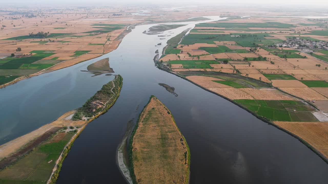 Sutlej River dividing around cultivated islands amid patchwork farmlands. Punjab, Pakistan