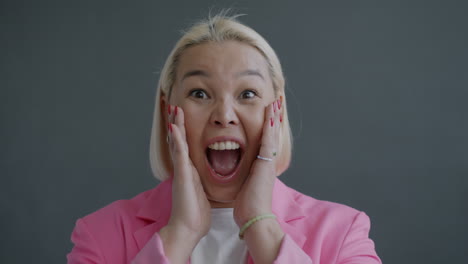 excited woman in pink blazer