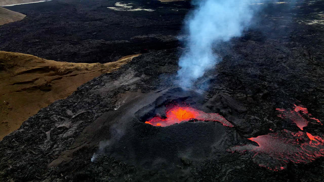 Ripresa aerea circolare molto ravvicinata della lava incandescente, del magma e delle ceneri che fuoriescono dalla bocca del cratere a Fagradalsfjall, Islanda.