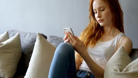 mujer usando teléfono móvil en la sala de estar 4k