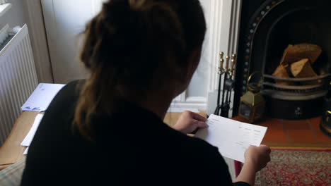 an unrecognizable female opening a debt letter