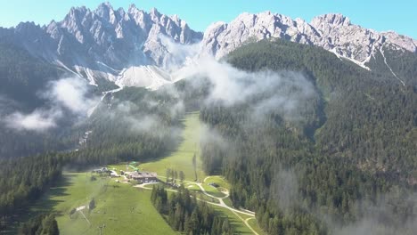 aerea di una pista da sci durante l'estate, alte cime montuose con nebbia nuvolosa, san candido alto adige