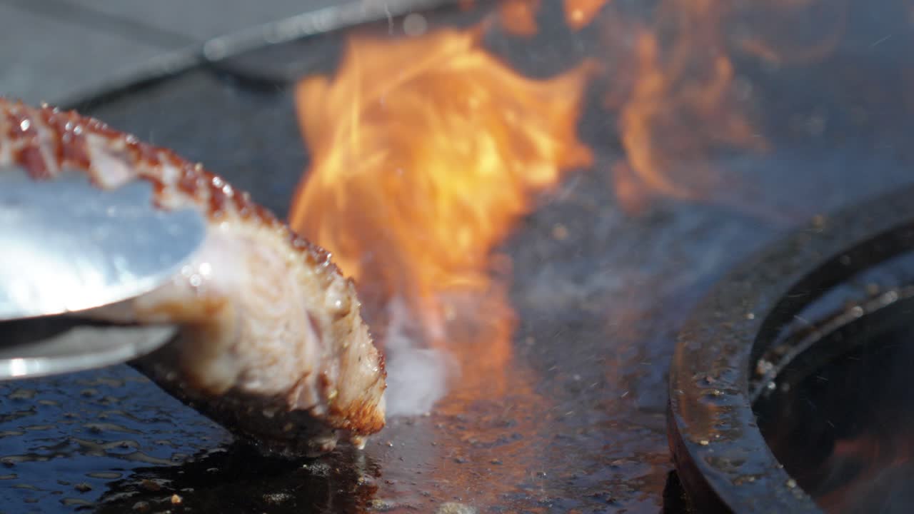 chicken breasts are being sealed and cooked on a metal BBQ during a summer party