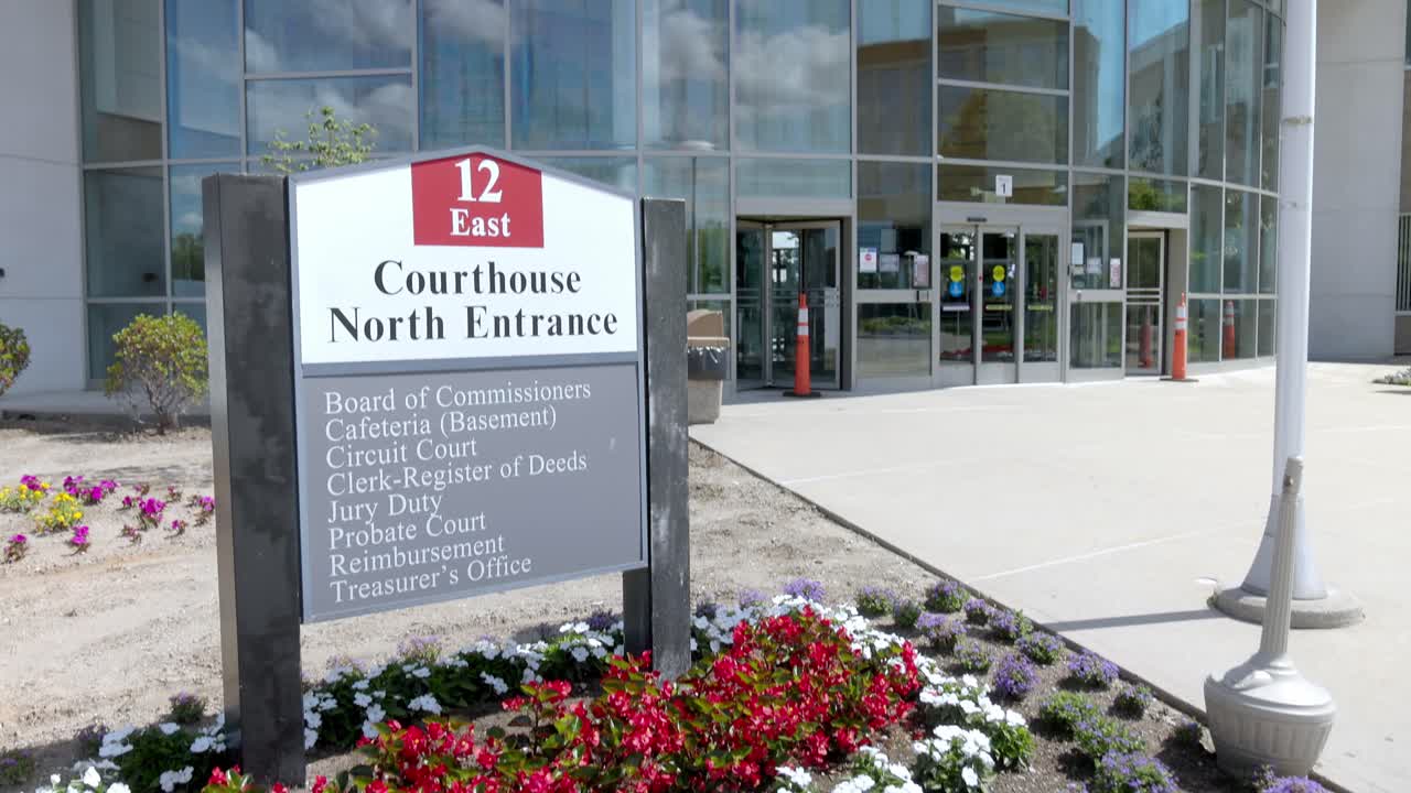 Oakland County Courthouse in Michigan at north entrance sign with gimbal video tilting up close up