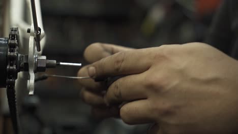 A bicycle mechanic installing a rear derailleur for gear shifting