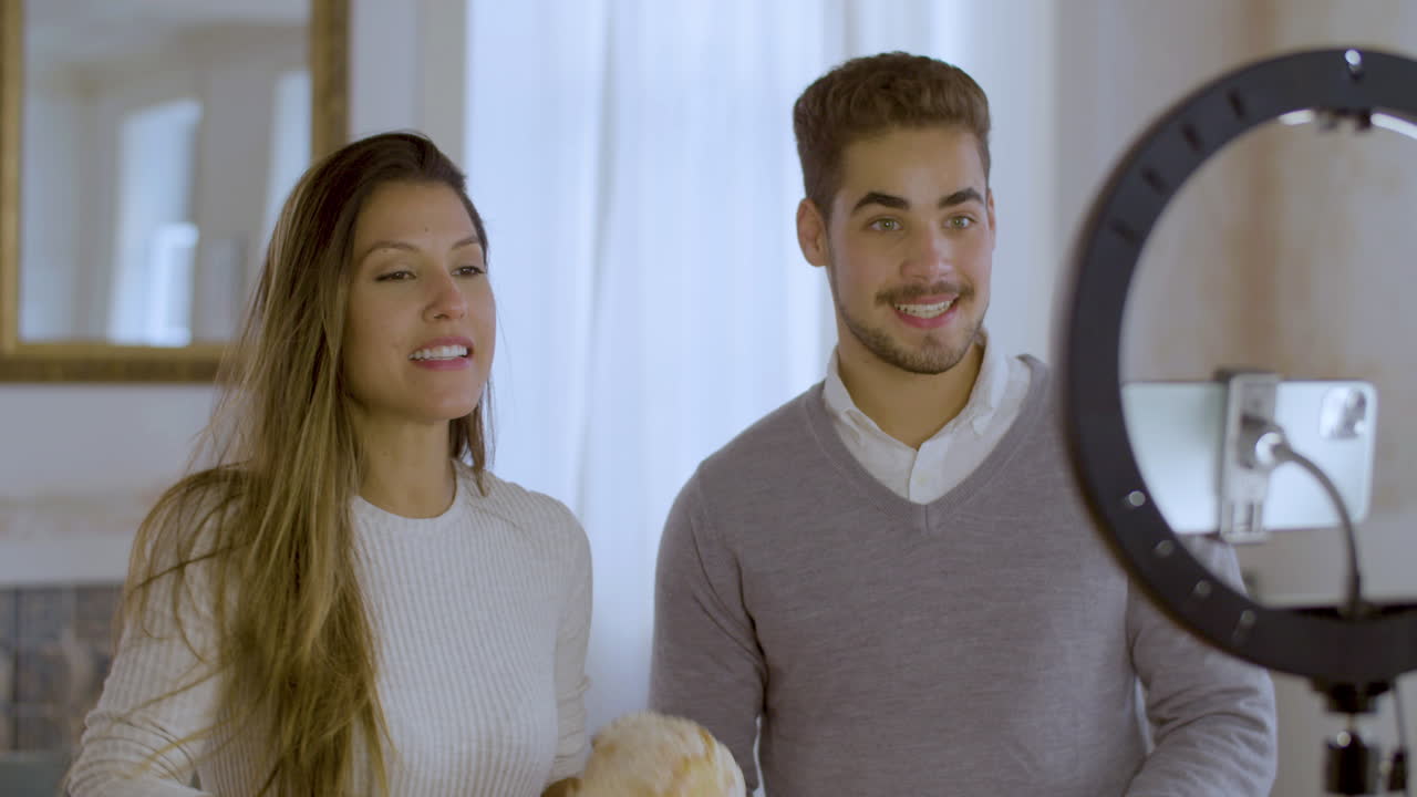 una joven pareja entusiasta grabando un video para un vlog de cocina.