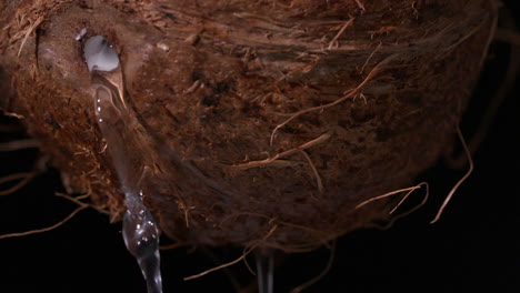 Water-leaking-out-of-coconut-on-black-background