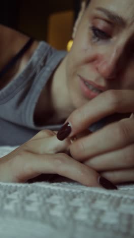 una mujer llorando en una cama.