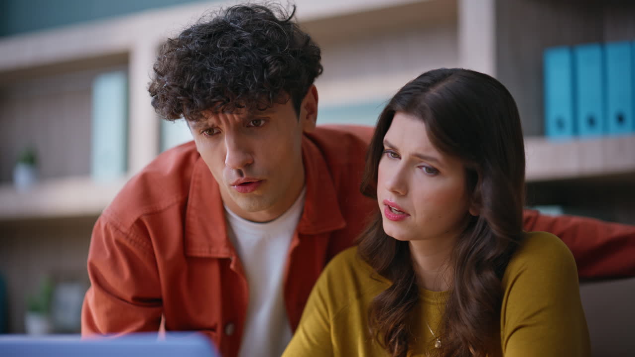 Colleagues reading bad news at laptop collaborating together on project closeup