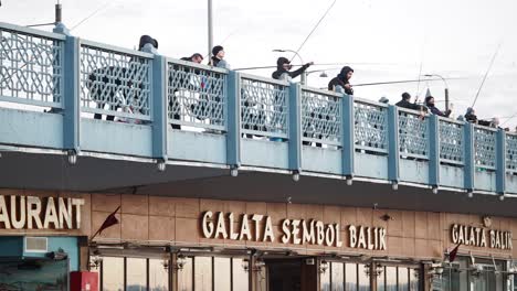 people fishing from the galata bridge in istanbul, turkey