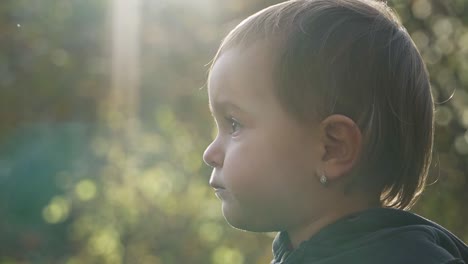 close up view of little girl sitting outside in golden light