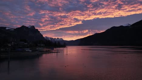 sunset over the walensee in switzerland. the sky is ablaze with vibrant hues of orange and purple, reflecting on the calm waters of the lake.