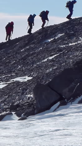 hikers climbing a rocky mountain