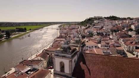 beautiful rooftops of alcacer do sal town on sado river coastline, aerial orbit view