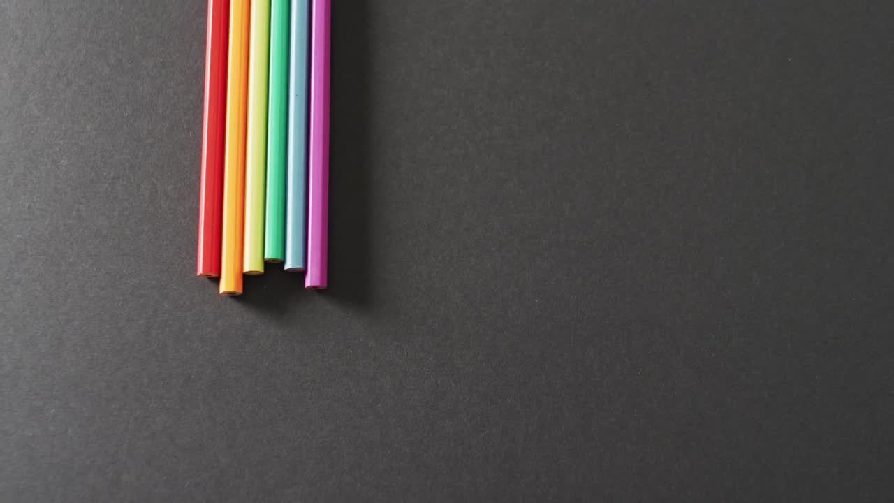 video de pajitas de arco iris sobre un fondo gris con espacio para copiar.