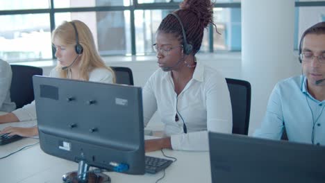 mix raced group of call center operators in headsets