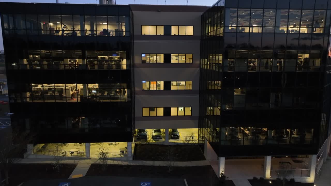 toma aérea ascendente del edificio de oficinas por la noche