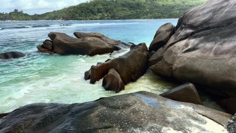 Mahe-Seychelles-,-huge-granitic-rock-boulders-on-the-shore,-wavy-and-agitated-ocean