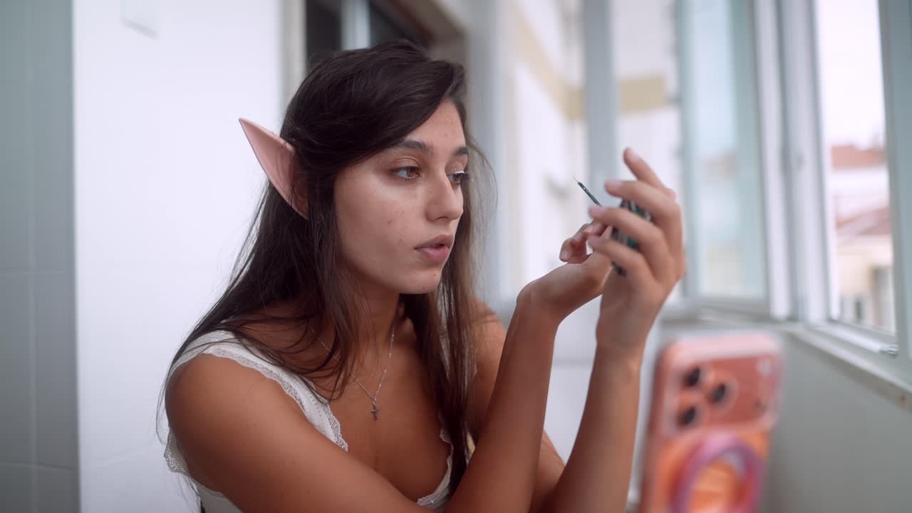 Young Woman with Elf Ears Applying Mascara for Fantasy Cosplay