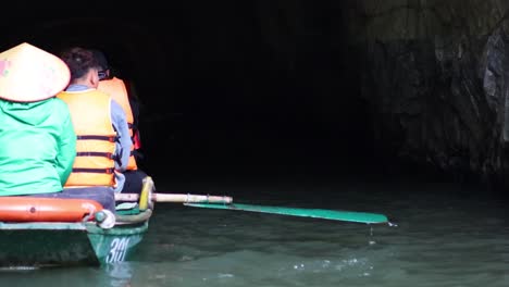 tourists rowing through a dark cave